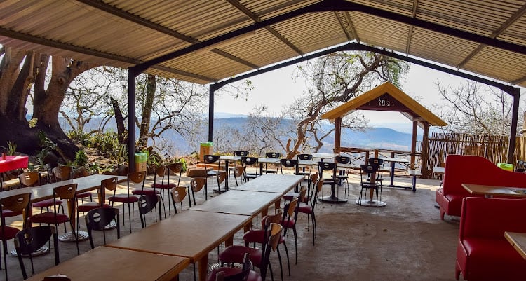 The covered entertainment area at Kanaan — long tables, chairs and an open view across the Lowveld valley.